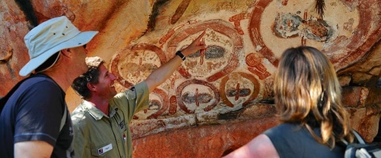 A guide showing passengers the wandjina rock art in the Kimberley